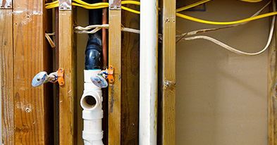 plumbing pipes being installed into walls in new home