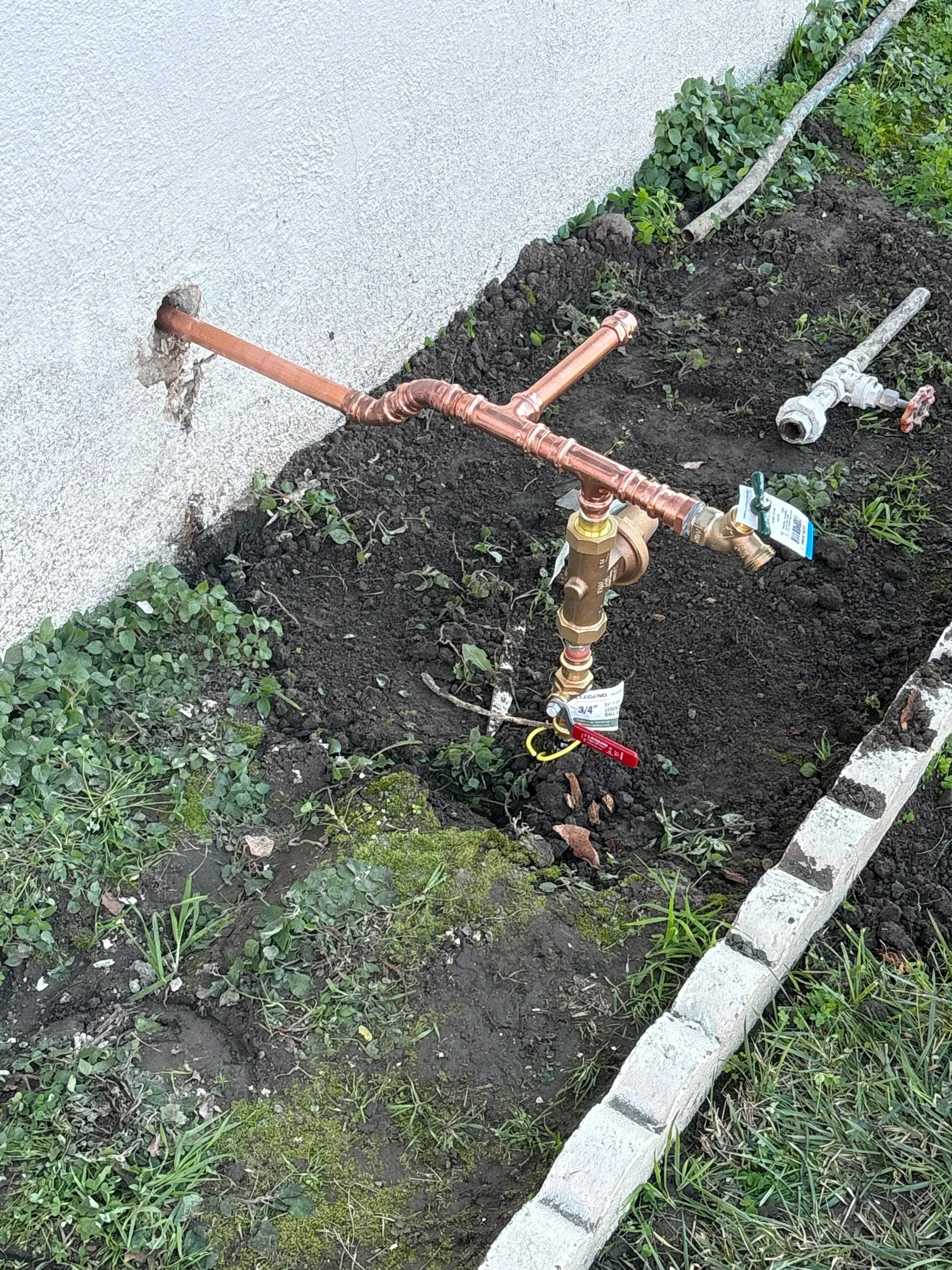 Copper water main with brass valves, meter, and shut-off installed in ground